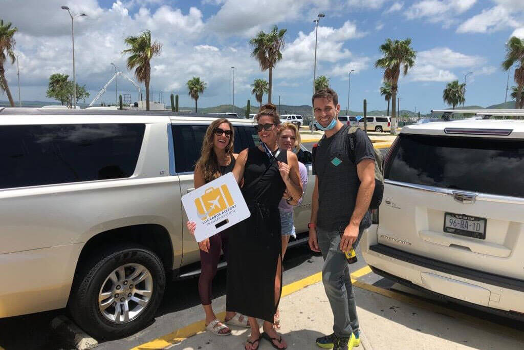 Group of four friends being picked up on a white Escalade luxury SUV | Cabo Airport Transportation